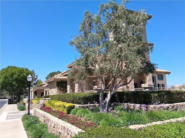 33 Corte Rivera, Lake Elsinore, CA 92532 - view of side of home featuring a tile roof, stone siding, and stucco siding