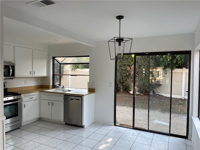 835 Plumwood St, Colton, CA 92324 - kitchen with a sink, appliances with stainless steel finishes, light tile patterned floors, and white cabinets