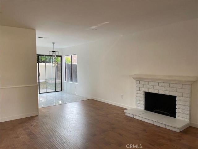 835 Plumwood St, Colton, CA 92324 - unfurnished living room featuring a brick fireplace, baseboards, visible vents, and wood finished floors