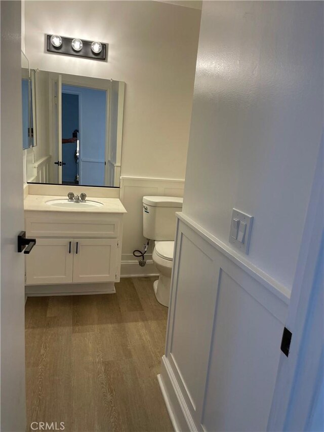 835 Plumwood St, Colton, CA 92324 - half bath with vanity, a wainscoted wall, toilet, and wood finished floors