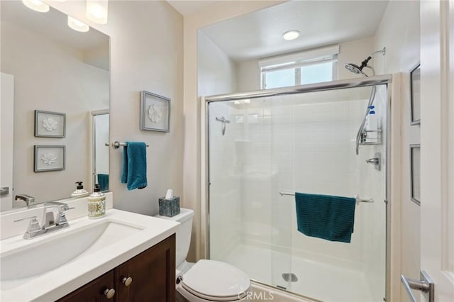 full bath with a shower stall, toilet, and vanity