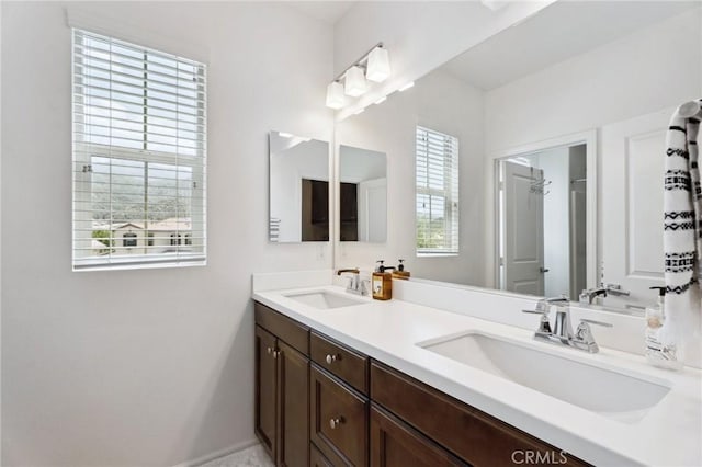 bathroom featuring double vanity and baseboards