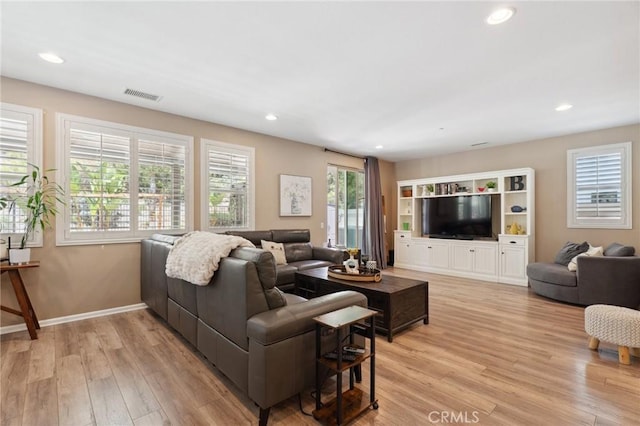 living room featuring light wood-style floors, recessed lighting, and baseboards
