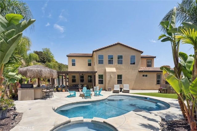 view of pool with a pool with connected hot tub, a patio, and a ceiling fan