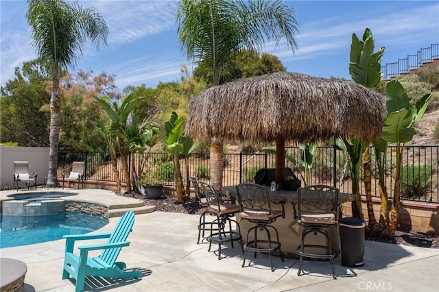 view of swimming pool featuring a patio, a fenced backyard, and a pool with connected hot tub