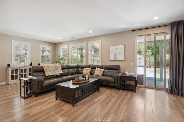 living room with light wood finished floors, recessed lighting, and baseboards