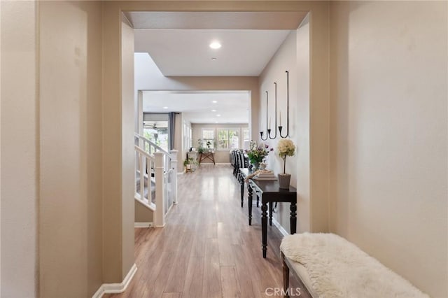 hallway featuring light wood-style floors and baseboards