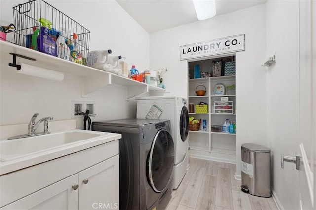 11266 Hutton Rd, Corona, CA 92883 - washroom featuring separate washer and dryer, light wood finished floors, and cabinet space