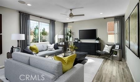 living room featuring baseboards, ceiling fan, and wood finished floors