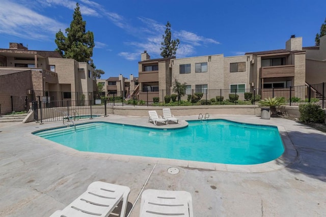 pool with fence and a residential view