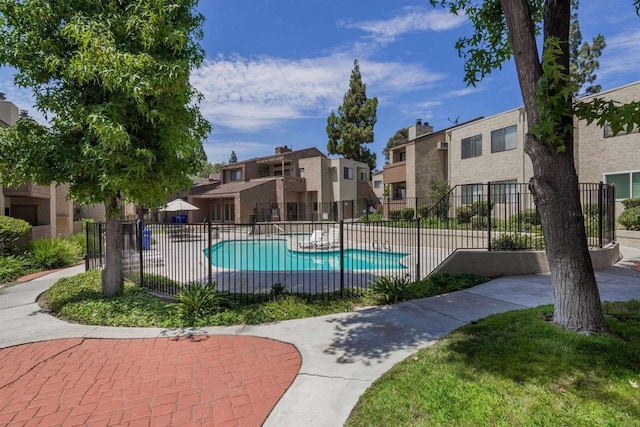 community pool featuring fence and a residential view