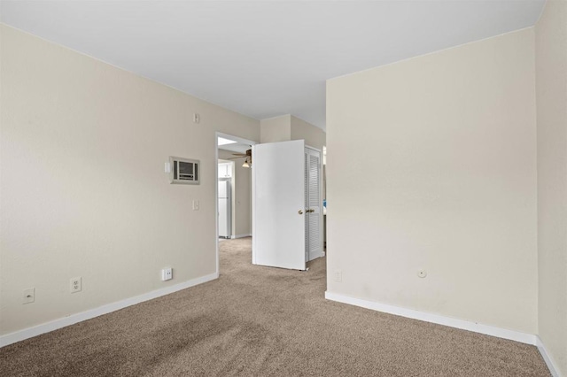 carpeted empty room featuring baseboards