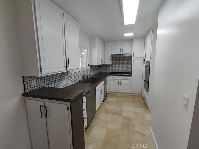 kitchen with dishwashing machine, dark countertops, decorative backsplash, and white cabinetry