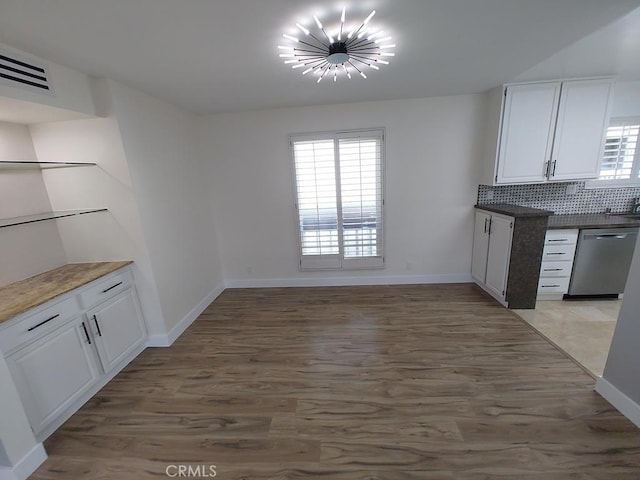 unfurnished dining area with baseboards, plenty of natural light, and light wood finished floors