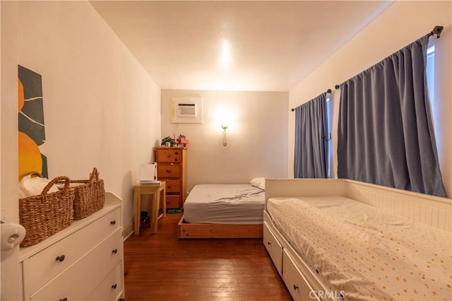 bedroom featuring dark wood-style flooring and a wall mounted air conditioner