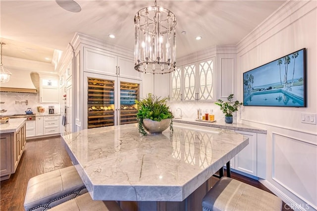 32 Panorama, Coto De Caza, CA 92679 - dining area featuring ornamental molding, dark wood-style flooring, a decorative wall, recessed lighting, and a chandelier