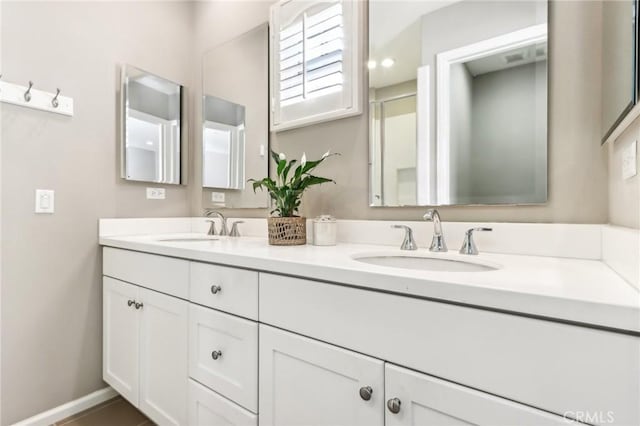 bathroom featuring double vanity and baseboards