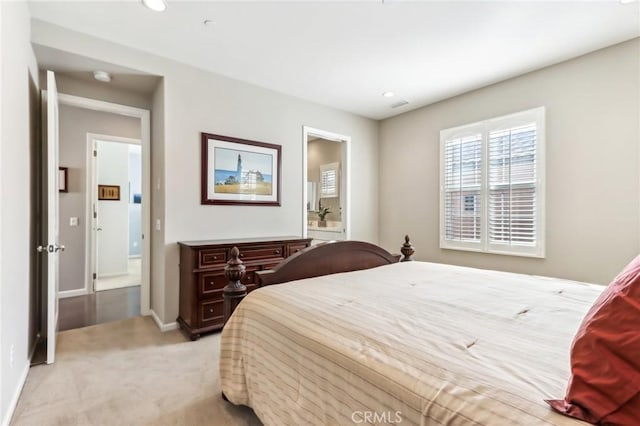 bedroom featuring light carpet, ensuite bathroom, recessed lighting, and baseboards