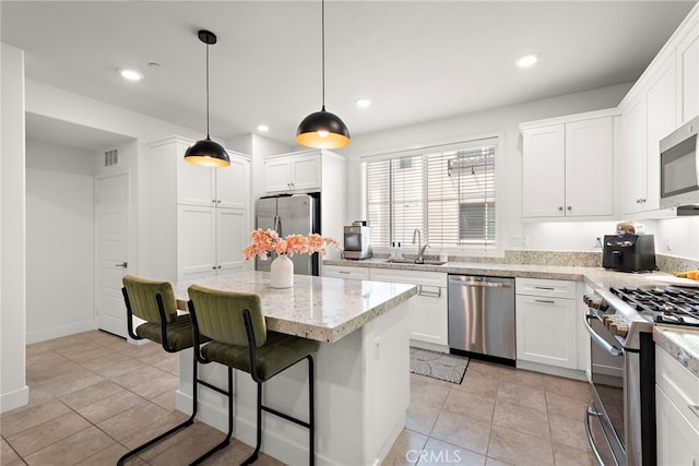 kitchen with a sink, appliances with stainless steel finishes, white cabinets, and recessed lighting