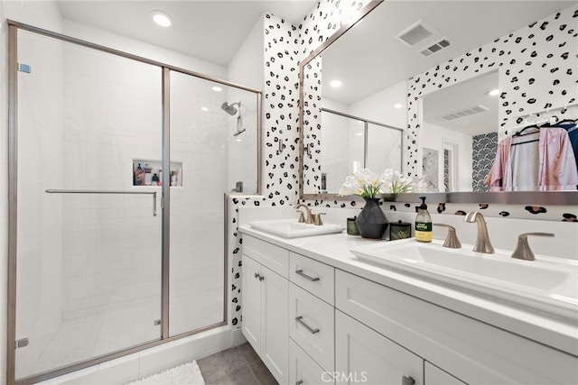 bathroom featuring visible vents, a sink, and a stall shower