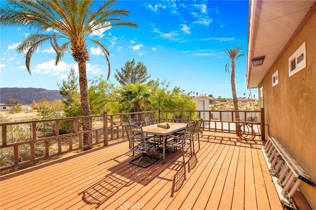 wooden deck with outdoor dining space and a mountain view