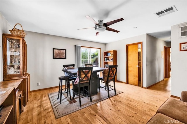 dining space featuring visible vents, a ceiling fan, baseboards, and light wood-type flooring
