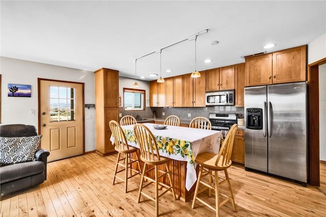 dining area featuring recessed lighting, track lighting, baseboards, and light wood-type flooring