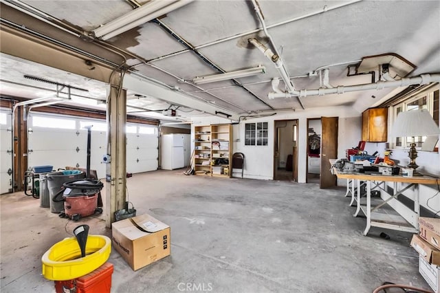garage featuring freestanding refrigerator and a garage door opener