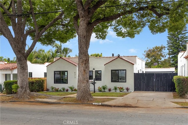 view of front of home featuring concrete driveway, fence, and stucco siding