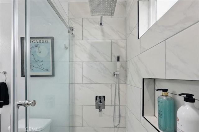 full bathroom with a tile shower and toilet