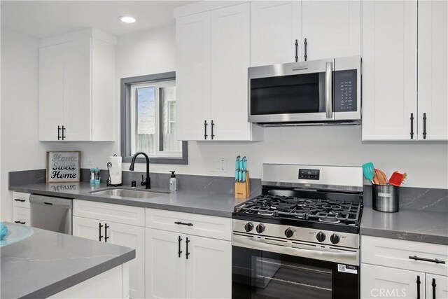 8313 Washington Ave, Whittier, CA 90602 - kitchen with stainless steel appliances, a sink, white cabinetry, recessed lighting, and dark countertops