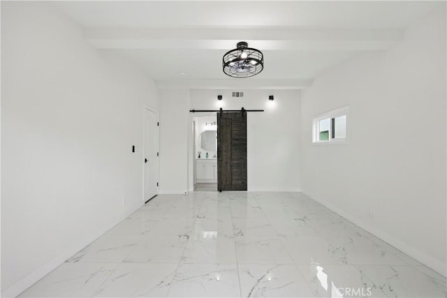 spare room featuring a barn door, marble finish floor, baseboards, beamed ceiling, and visible vents