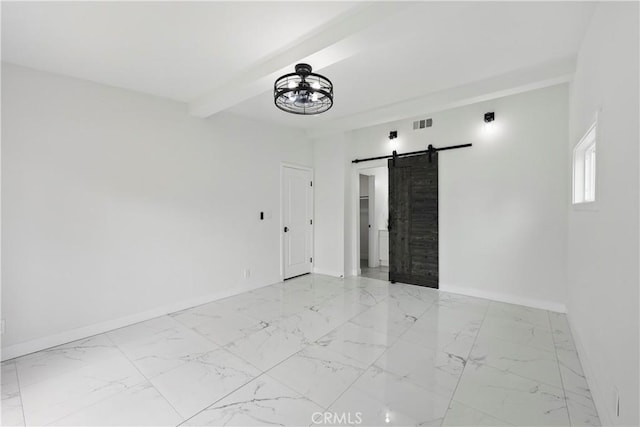 spare room featuring baseboards, beam ceiling, a barn door, and marble finish floor