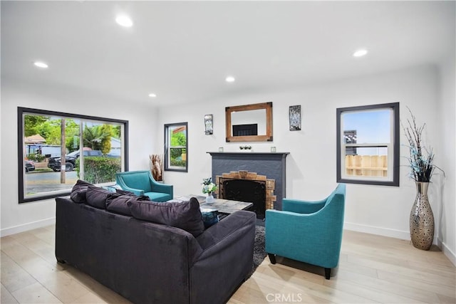 living area with light wood-style floors, recessed lighting, baseboards, and a fireplace