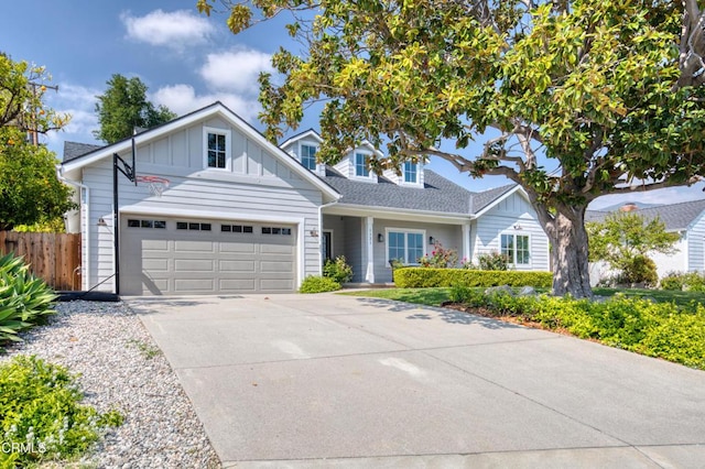 view of front facade with a garage, board and batten siding, fence, and driveway