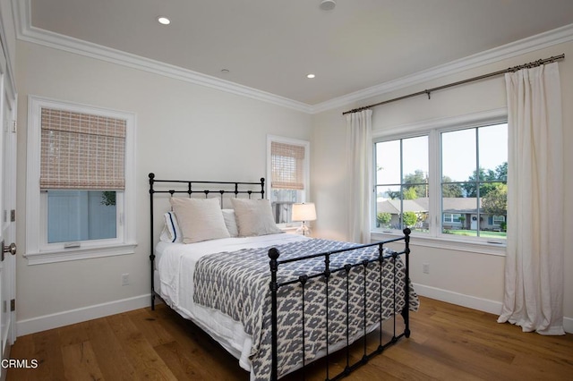 bedroom with baseboards, ornamental molding, recessed lighting, and wood finished floors