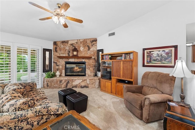living area with carpet flooring, ceiling fan, visible vents, and a stone fireplace