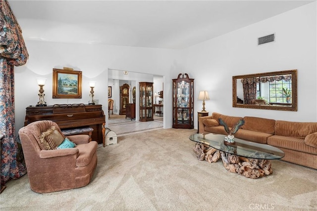 carpeted living room featuring visible vents and lofted ceiling