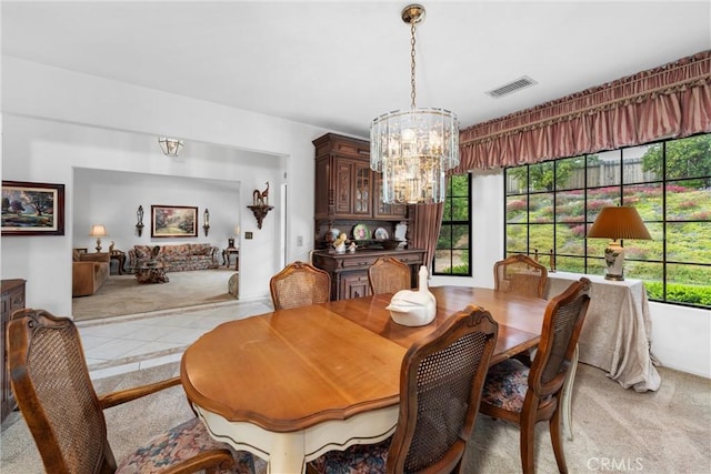 dining room with visible vents, light colored carpet, light tile patterned flooring, and a notable chandelier