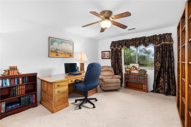 home office with light colored carpet, a ceiling fan, and visible vents