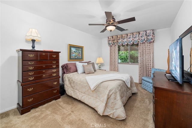 bedroom featuring light colored carpet, baseboards, and ceiling fan