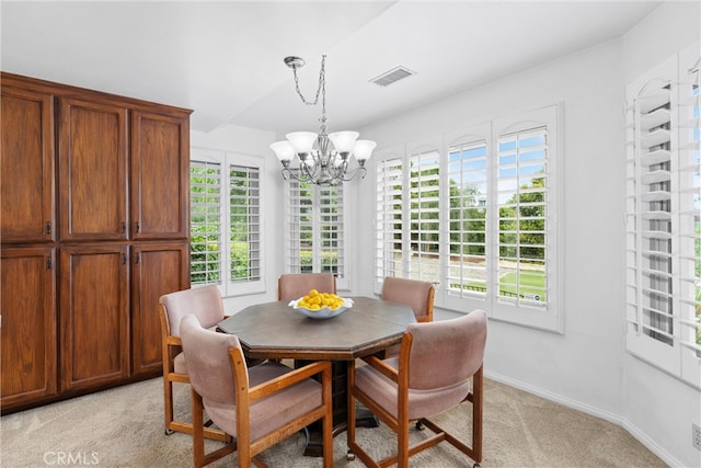 dining space featuring visible vents, light carpet, an inviting chandelier, and a wealth of natural light