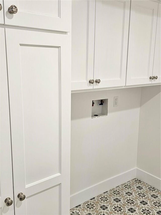 clothes washing area featuring cabinet space, baseboards, and washer hookup
