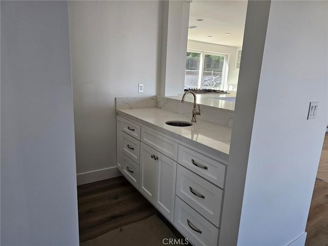 bathroom with vanity, baseboards, and wood finished floors