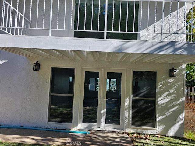 entrance to property featuring french doors and stucco siding
