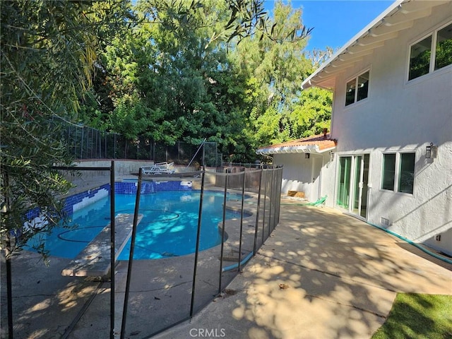 view of swimming pool featuring a fenced backyard, a fenced in pool, and a patio area