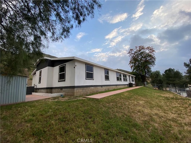 exterior space featuring a lawn, a patio, fence, and central AC unit