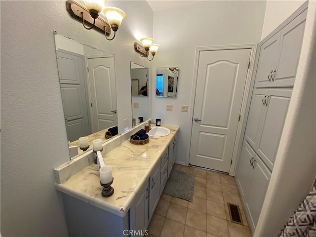 bathroom featuring visible vents, a textured wall, tile patterned flooring, and vanity