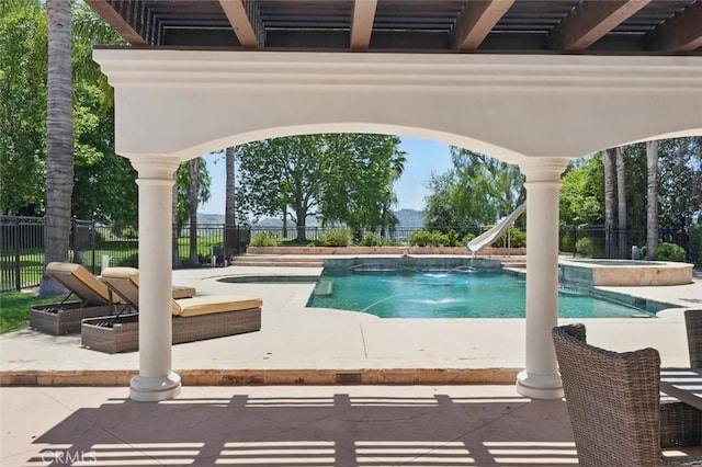 view of swimming pool with a pool with connected hot tub, a patio, and a water slide