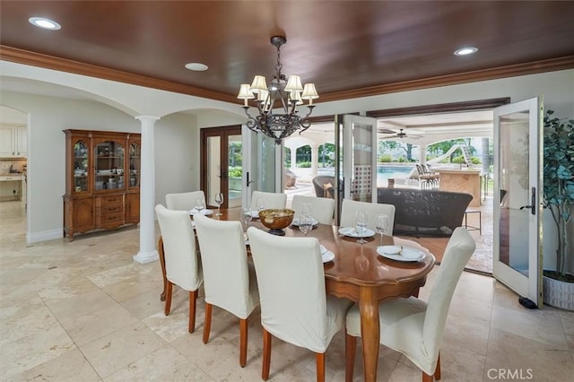 dining area with arched walkways, french doors, a chandelier, ornamental molding, and plenty of natural light